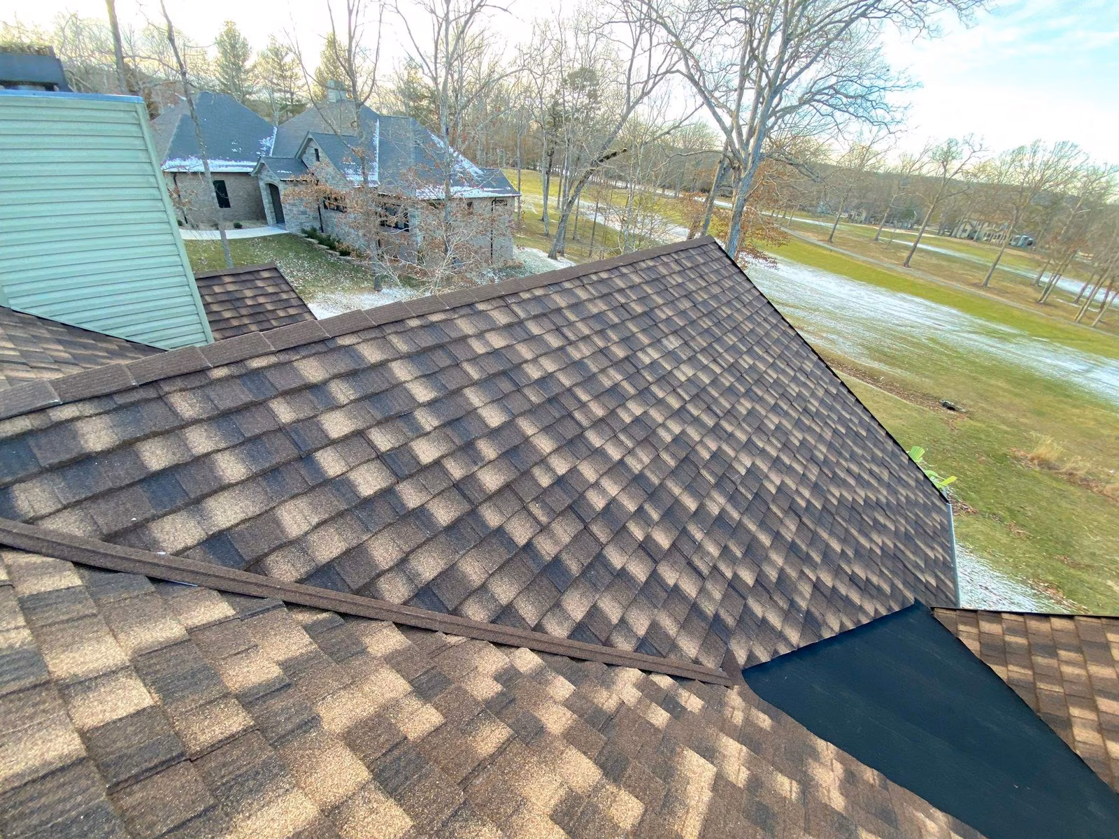 New brown architectural shingles meeting at a roof valley